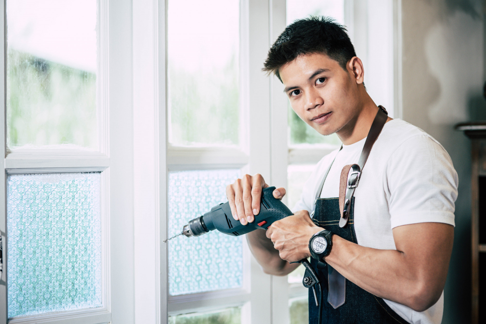 Carpenter Holds Drill Drills Window